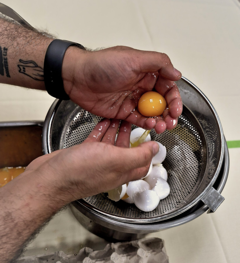 Hands preparing an egg in the kitchen