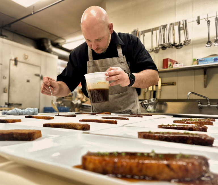 Gary Shelly adding sauce to plates at Spring Supper