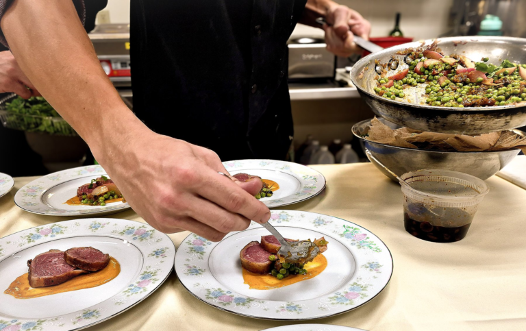 Hands adding the finishing details to a plate