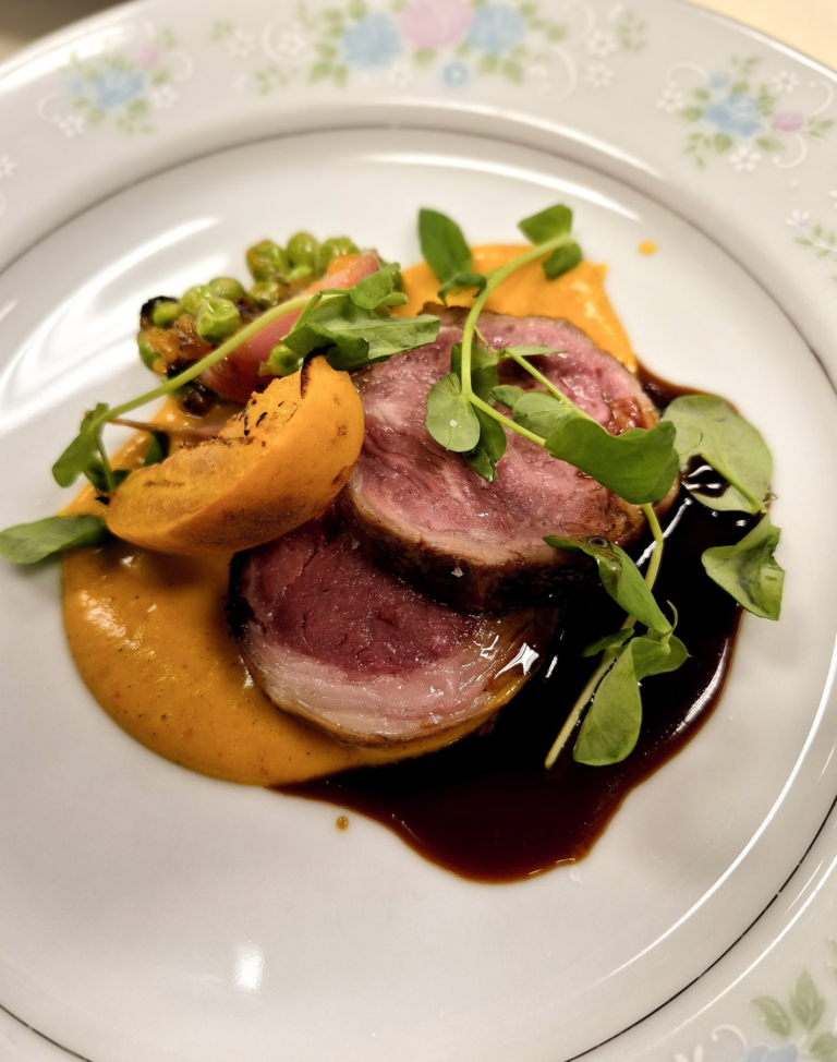 A finished course with greens and golden vegetables