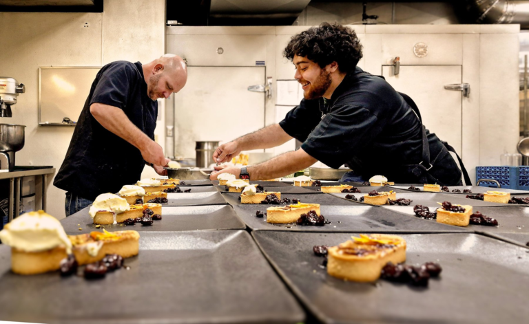 Gary Shelly, at left, working on dessert plates with another cook at Spring Supper